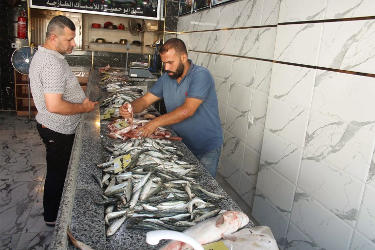 فلسطين/ غزة/ ياسر البنا/ مواطن فلسطيني يشتري أسماكا داخل متجر لبيع الأسماك في غزة/ مصدر الصورة: ياسر البنا