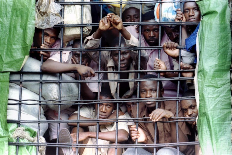 Prisoners within the Gitarama Prison which holds some 6,500 inmates look out from behind the bars of a dormitory April 4. There are some 68,000 prisoners being held in overcrowded and inadequate Rwandan jails