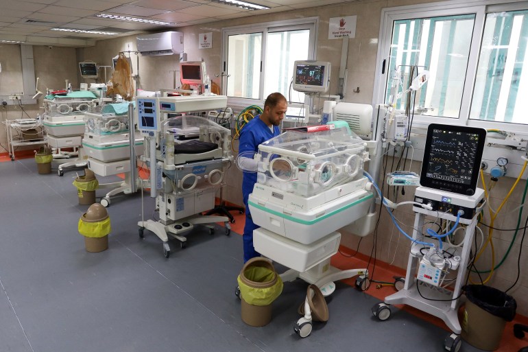 A medical worker assists a premature Palestinian baby who lies in an incubator at the maternity ward of Shifa Hospital, which according to health officials is about to shut down as it runs out of fuel and power, as the conflict between Israel and the Palestinian Islamist group Hamas continues, in Gaza City October 22, 2023. REUTERS/Mohammed Al-Masri