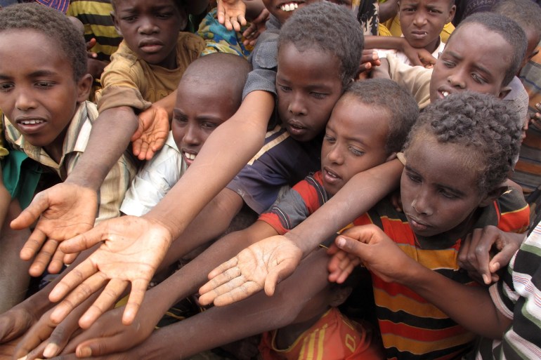 DADAAB, SOMALIA-AUGUST 15: Unidentified children stretch out their hands at the Dadaab refugee camp where thousands of Somalian wait for help because of hunger on August 15, 2011, in Dadaab, Somalia.