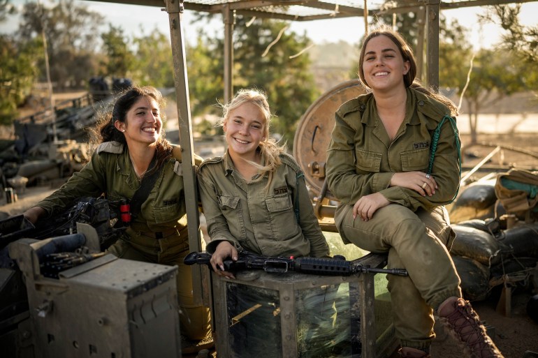 SOUTHERN ISRAEL - NOVEMBER 15: Female Israeli army soldiers pose on their armoured fighting vehicle at a staging area near the border with Gaza on November 15, 2023 in Southern Israel. More than month after Hamas's Oct. 7 attacks, the country's military has continued its sustained bombardment of the Gaza Strip and launched a ground invasion to vanquish the militant group that governs the Palestinian territory. (Photo by Christopher Furlong/Getty Images)