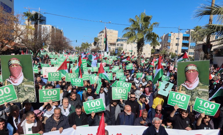 Demonstrators carry flags and signs reading: "100 days of Resilience, sacrifice, heroism and pride" during a protest in support of Palestinians in Gaza, amid the ongoing conflict between Israel and Palestinian Islamist group Hamas, in Amman, Jordan January 19, 2024. REUTERS/Jehad Shelbak