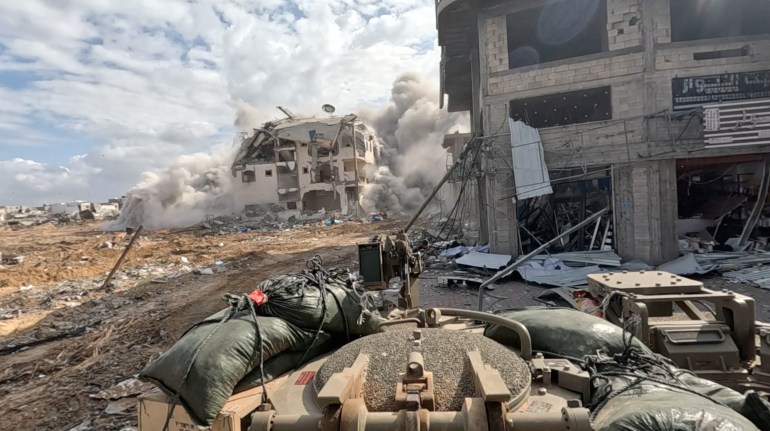 Smoke rises from a building as Israeli soldiers operate in the Gaza Strip amid the ongoing conflict between Israel and the Palestinian Islamist group Hamas, in this screen grab taken from a handout video released on December 4, 2023. Israel Defense Forces/Handout via REUTERS THIS IMAGE HAS BEEN SUPPLIED BY A THIRD PARTY