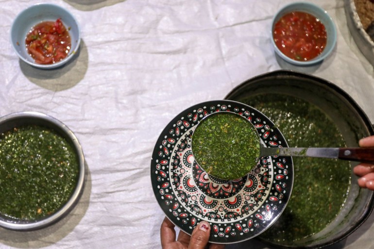 Making sure everyone gets their share, Siham diligently distributed the dishes as the call to Maghrib prayer announced the beginning of iftar [Abdelhakim Abu Riash/Al Jazeera]