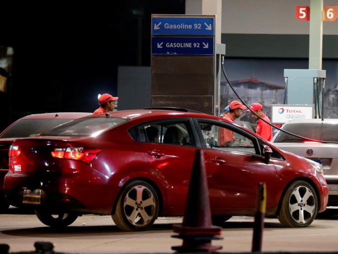 Workers fill cars as people queue and wait in their cars at a Total petrol station early on Friday, after the central bank floated the pound currency, in Cairo, Egypt, November 4, 2016. REUTERS/Amr Abdallah Dalsh