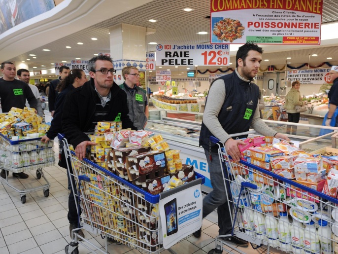 Milk producers push trolleys filled with dairy products of French group Lactalis during an action on December 6, 2013 in a supermarket of Le Mans to defend 'fair prices' and to protest against industrialists of the food-processing industry. AFP PHOTO / JEAN-FRANCOIS MONIER