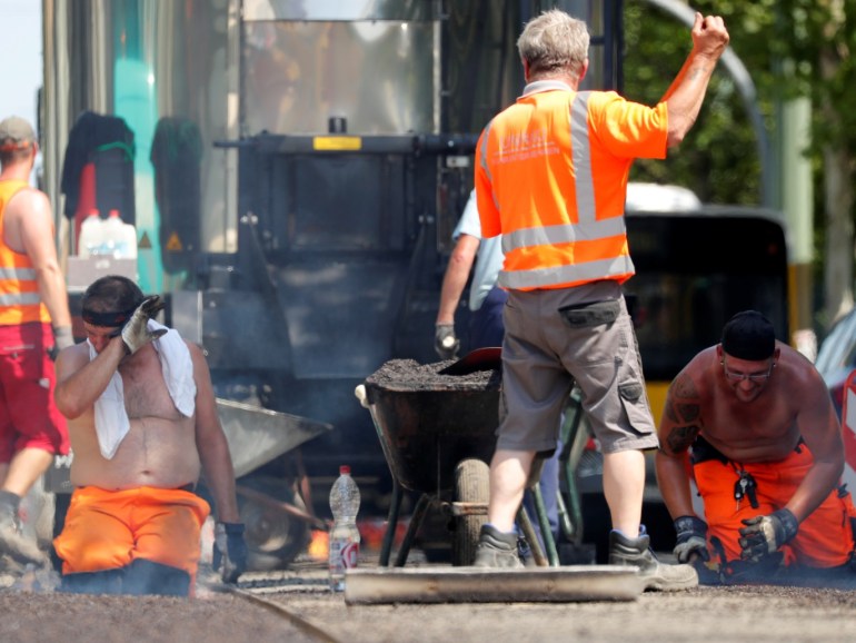 Construction workers renew the tarmac of a street with bitumen as temperatures reach new record highs in Berlin, Germany, July 25, 2019. REUTERS/Fabrizio Bensch