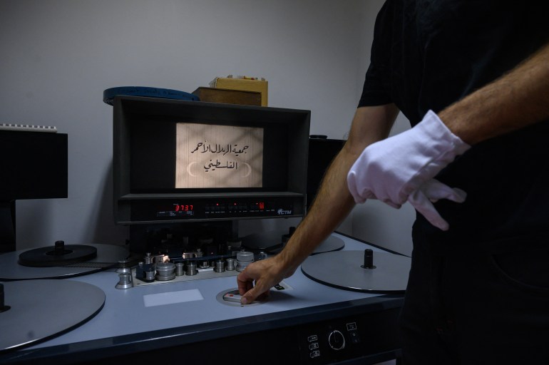 Archivist Matthieu Larroque inspects a reel of film showing scenes of daily life in Palestine, part of a collection of 40 Palestinian films made between 1960 and 1980, at the Conservation and Research Center of the Toulouse Cinematheque, in Toulouse, southwestern France, on August 1, 2024. - In the early 1980s, the Palestinian Film Institute in Beirut, where around a hundred militant films were stored, was bombed by Israel during the Lebanon war. Its director, Khadijeh Habashneh, fled the country, leaving the reels behind. Almost 40 years later, the 79-year-old former director of the Institute has managed to collect 40 short and medium-length films, in 16 and 30 mm formats, which will be shown to the general public at the Cine Palestine festival in Toulouse. (Photo by Ed JONES / AFP)