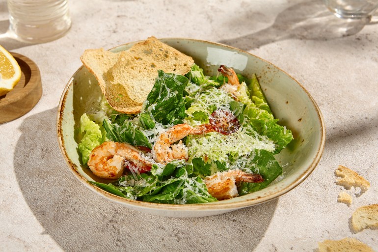 Authentic Caesar Salad with Shrimp in Sunlit Still Life Setting.; Shutterstock ID 2484330281; purchase_order: AJA; job: ; client: ; other: