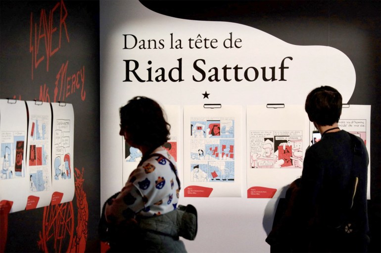 Visitors look at creations on display at the Riad Sattouf exhibition at Vaisseau Moebius during the 51st Angouleme International Comics Festival in Angouleme, western France, on January 24, 2024. (Photo by YOHAN BONNET / AFP)