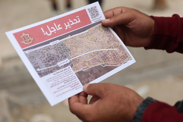 A Palestinian inspects a flyer, dropped by the Israeli army and ordering people to evacuate the area, in Jabalia north of Gaza City on October 6, 2024. - The Israeli military said on October 6, its forces surrounded the Jabaliya area of northern Gaza in response to indications Hamas was rebuilding despite nearly a year of strikes and fighting. (Photo by Omar AL-QATTAA / AFP)