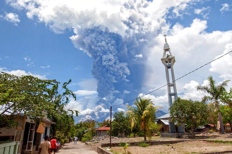 Schoolchildren run during the eruption of Mount Lewotobi Laki-Laki, as seen from Lewolaga village in East Flores, East Nusa Tenggara on November 7, 2024. (Photo by ARNOLD WELIANTO / AFP)