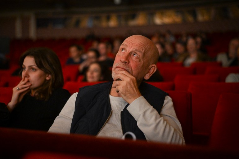 This picture taken on November 6, 2024, shows US actor John Malkovich watching the dress rehearsal for the play "Arms and the Man" which he directed at the Bulgarian National Theatre in Sofia. - A 19th century play directed by US actor John Malkovich has caused a stir in Bulgaria, with critics slamming what they called the "insulting" portrayal of Bulgarians in the production. Last week's premiere of "Arms and the Man" by renowned Irish-born playwright George Bernard Shaw sparked raucous protests among nationalist groups. Holding up banners that read "Malkovich go home", angry protesters blocked access to the National theatre in the capital Sofia before attempting to storm it, accusing the 70-year-old director of ridiculing the country's history and its citizens. (Photo by Nikolay DOYCHINOV / AFP)