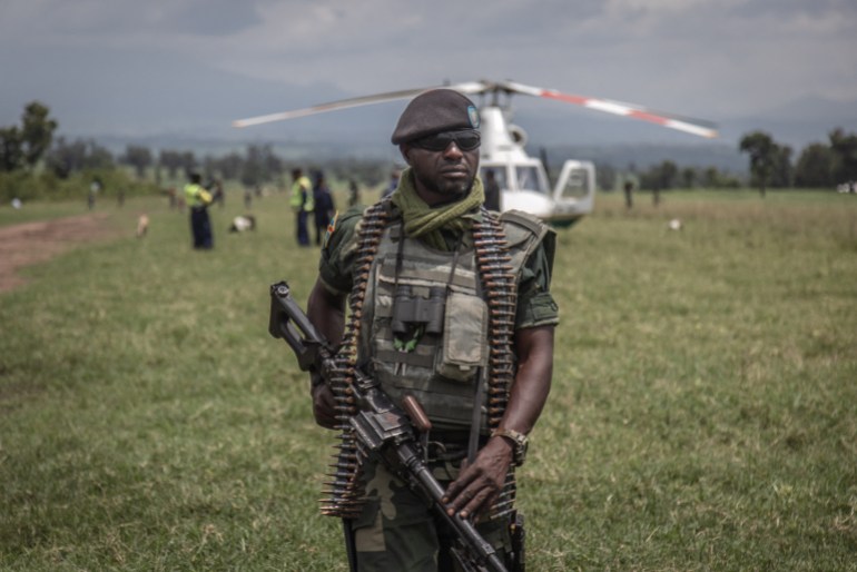 A soldier of the Democratic Republic of Congo's armed forces holds his weapon during a security patrol around the Kiwanja airfield days after clashes with the M23 rebels in Rutshuru, 70 kilometers from the city of Goma in eastern Democratic Republic of Congo, on April 3, 2022. (Photo by Guerchom NDEBO / AFP)