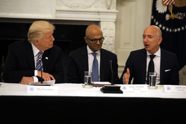 U.S. President Donald Trump and Satya Nadella, CEO of Microsoft Corporation listen as Jeff Bezos, CEO of Amazon speaks during an American Technology Council roundtable at the White House in Washington, U.S., June 19, 2017. REUTERS/Carlos Barria