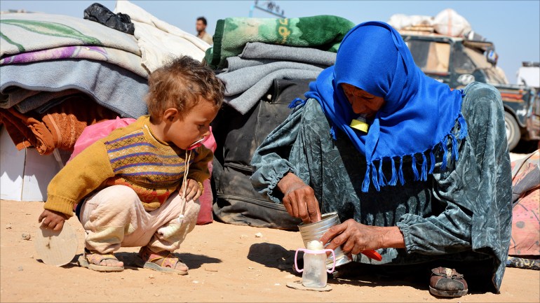 epaselect epa06261925 A Displaced Syrian woman who fled from Deir Ezzor and Al-Raqqa cities occupied by Islamic State (IS) group fighters, prepares milk to her child in Qana refugee camp, southern Hassakeh province, 11 October 2017 (Issued 12 October 2017). The flow of displaced Syrians from the governorates of Deir Ezzor and al-Raqqa continues to Qana camp south of al-Hassakah city, to escape the fighting between the Islamic state organization and the fighting forces. The number of displaced people reached 27 thousand, while the capacity of the camp is 12 thousand, which let for the camp to stop receiving refugees for four days. EPA-EFE/YOUSSEF RABIH YOUSSEF