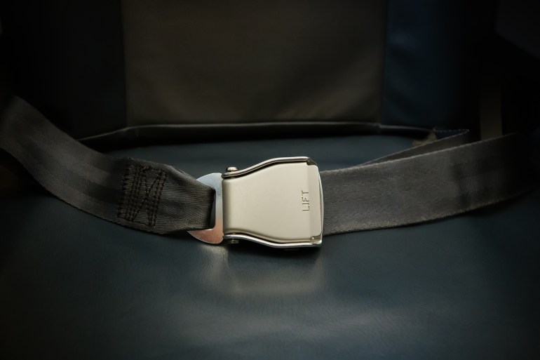 Seat belt on seat shot in airplane. Dark tone and Selective focus. Fastened safety belt. the concept of safe airplane flight