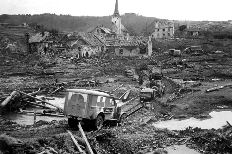 View of a US Army Red Cross ambulance threading its way over a makeshift bridge, and across the wreckage and devastation of the city of Lunebach, Germany, March 1945. (Photo by Office of War Information/Interim Archives/Getty Images)
