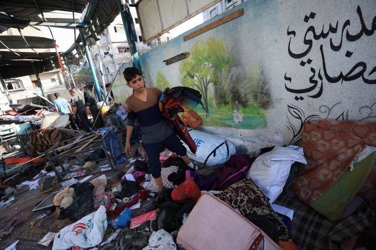 A Palestinian inspects the damage at a school sheltering displaced people, near a wall reading, "my school is my civilization", following an Israeli strike, in Gaza City, May 26, 2025. REUTERS/Dawoud Abu Alkas